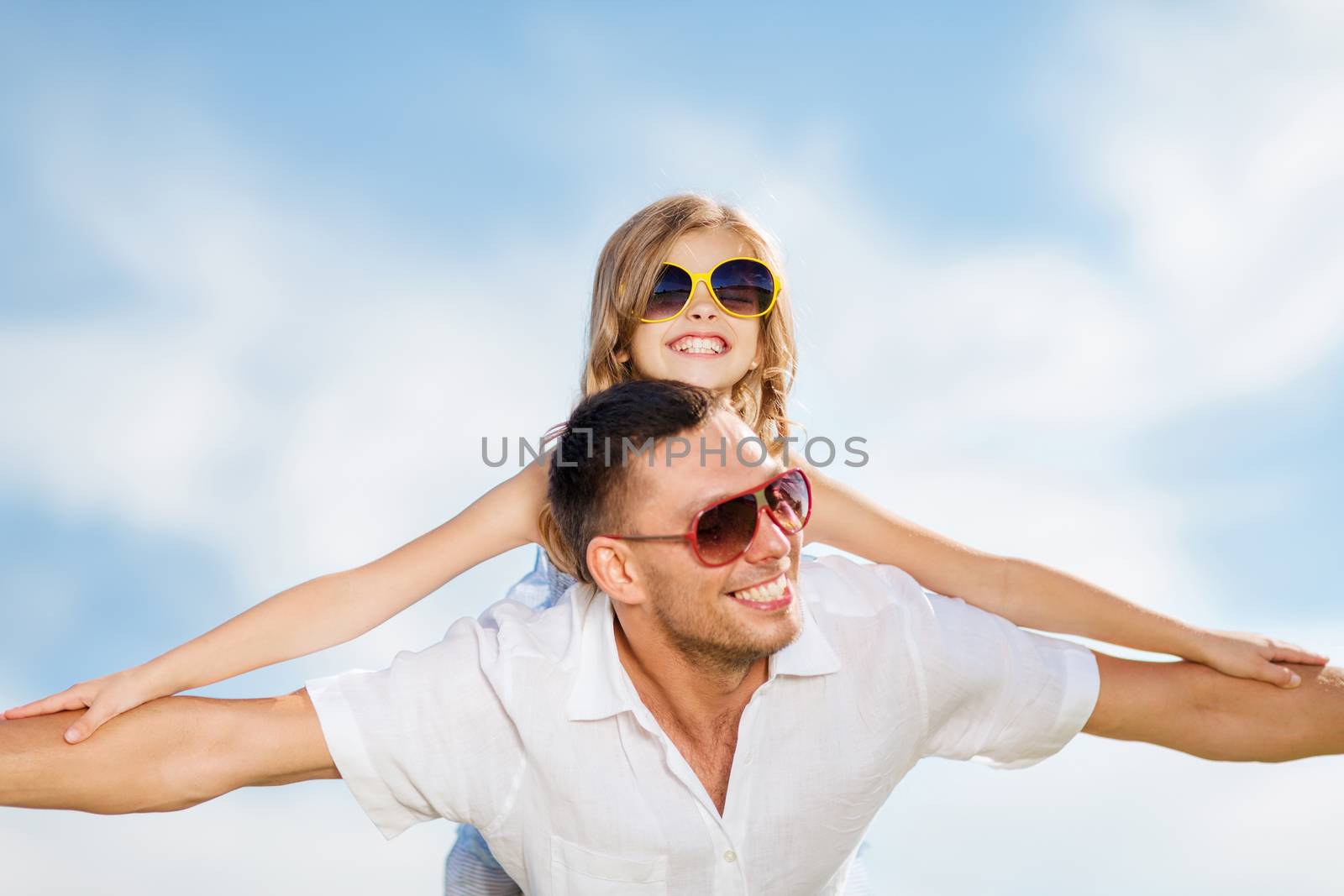 happy father and child in sunglasses over blue sky by dolgachov