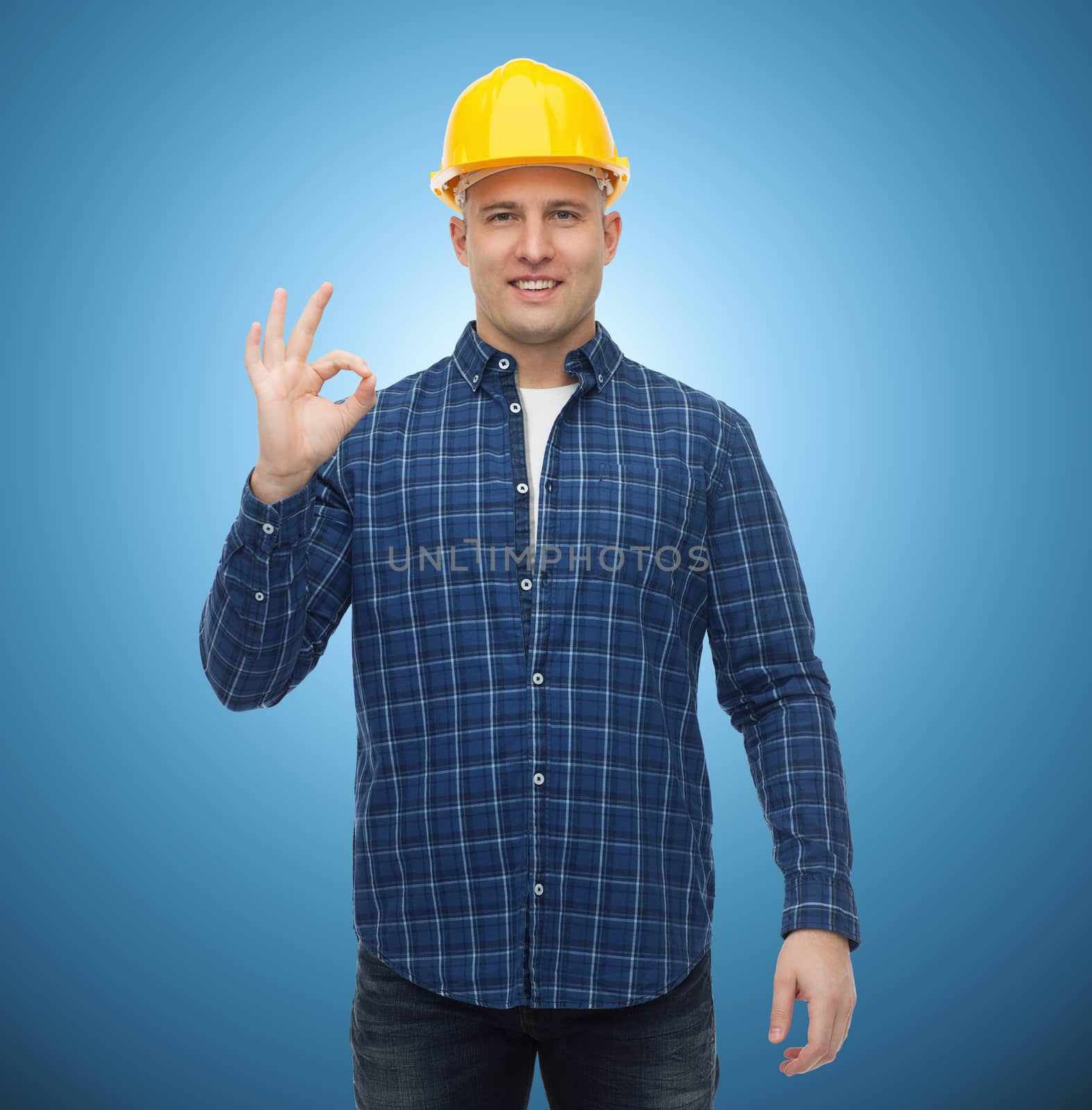 repair, construction, building, people and maintenance concept - smiling male builder or manual worker in helmet showing ok sign over blue background