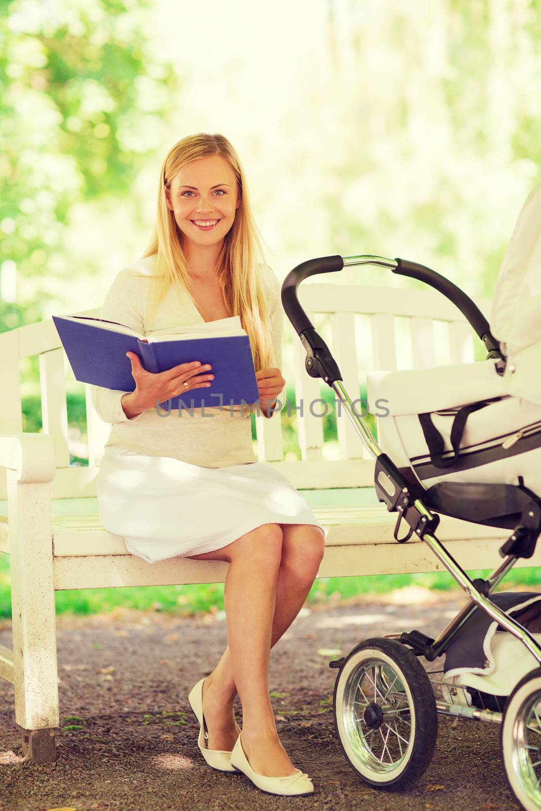 family, child, leisure, education and parenthood concept - happy mother with baby stroller reading book in park