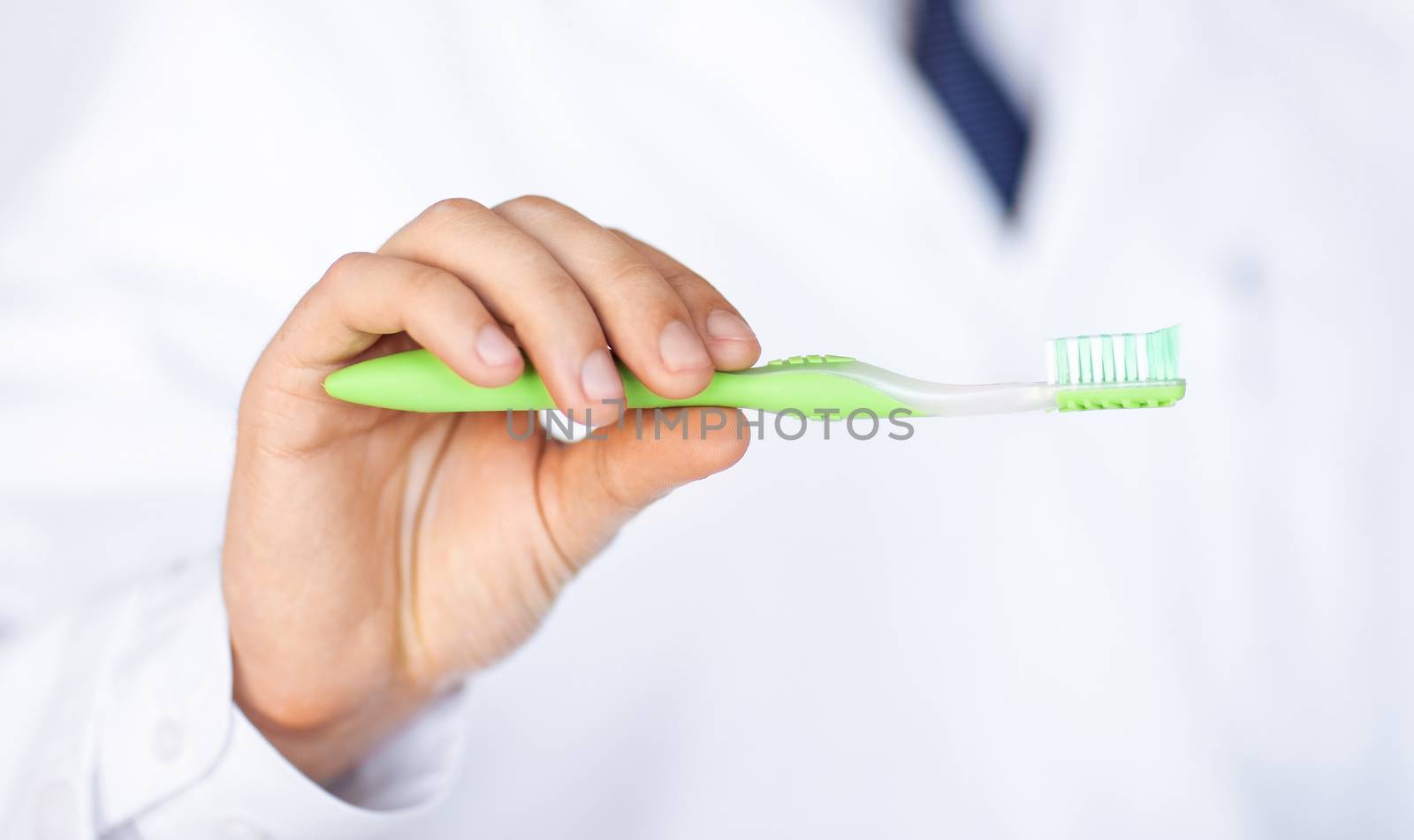 close up of male dentist or stomatologist holding toothbrush..