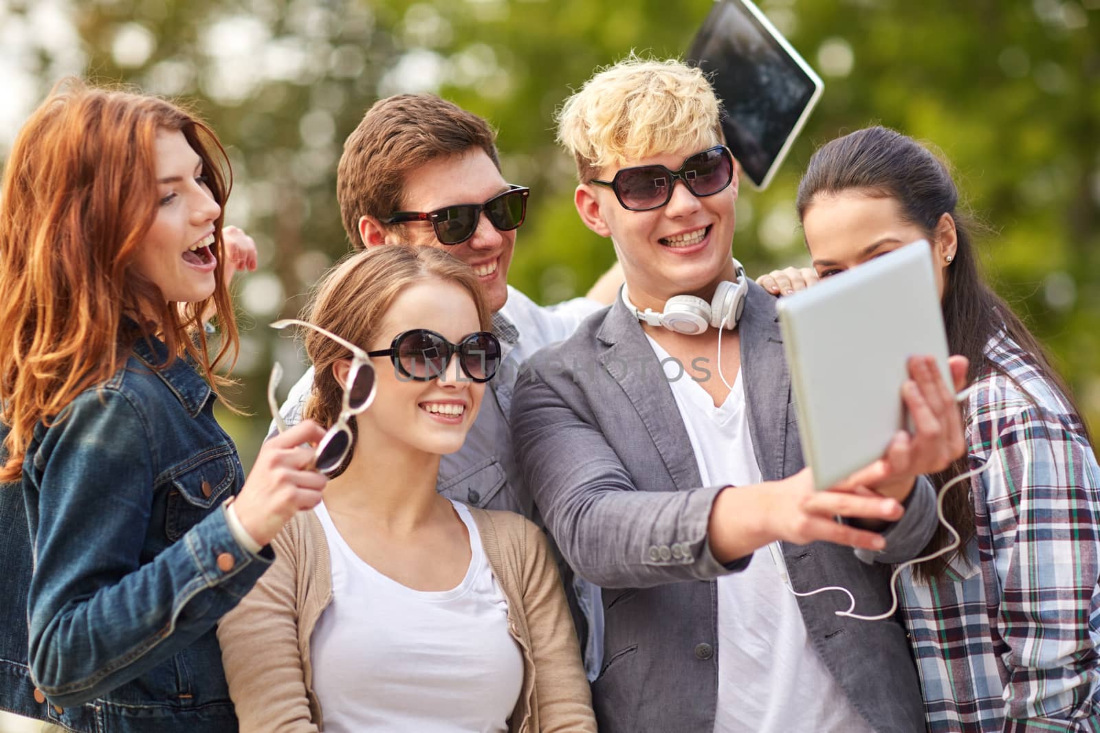 students or teenagers with tablet pc taking selfie by dolgachov