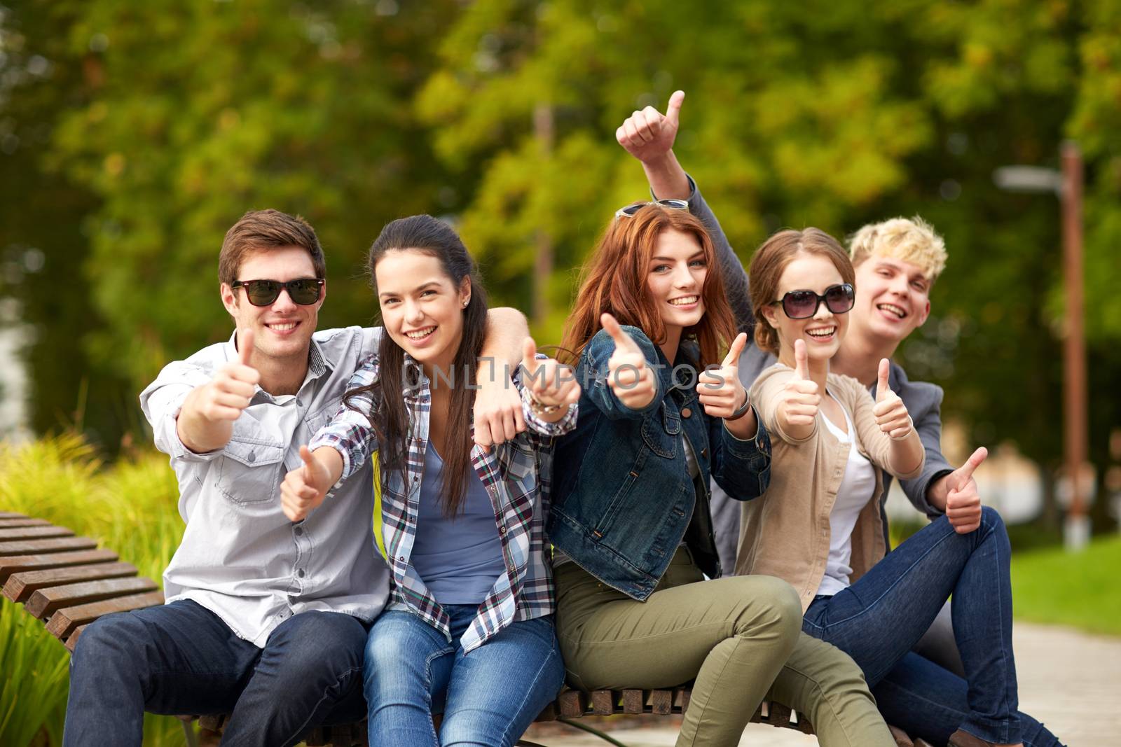 group of students or teenagers showing thumbs up by dolgachov
