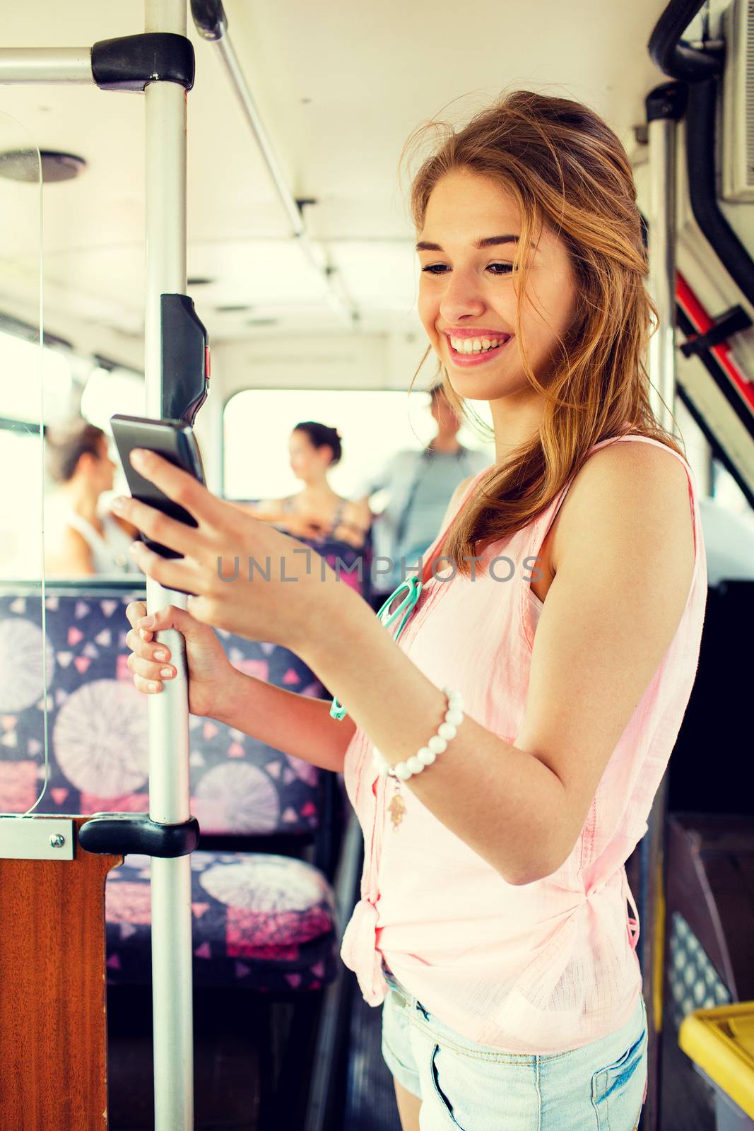 travel, vacation, summer, transport and people concept - smiling teenage girl with smartphone going by bus