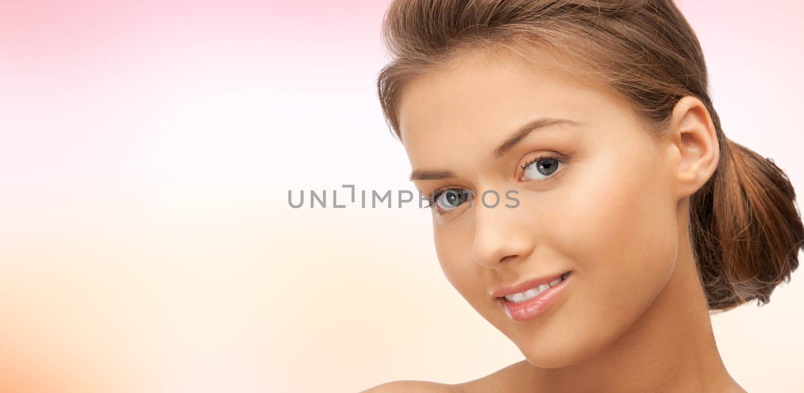 beauty, people and health concept - beautiful young woman face over pink background