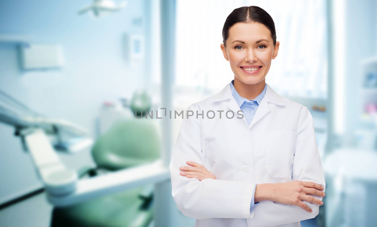 people, medicine, stomatology and healthcare concept - happy young female dentist with tools over medical office background