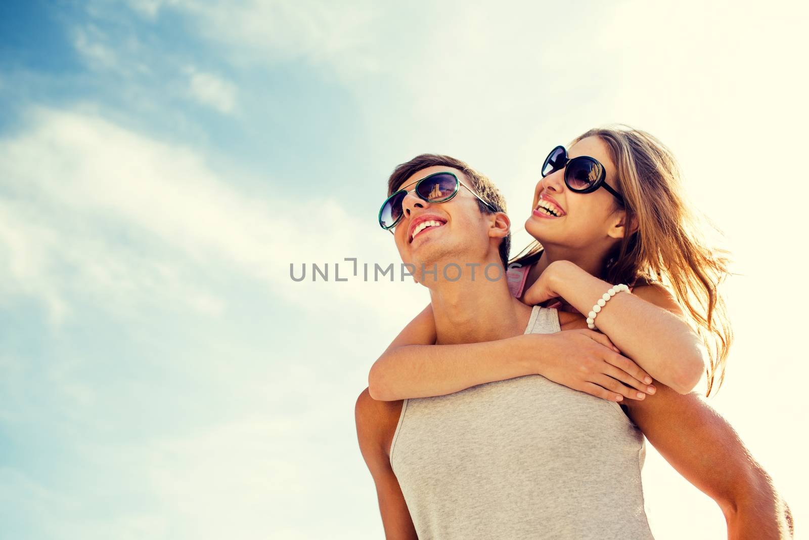 smiling couple having fun over sky background by dolgachov