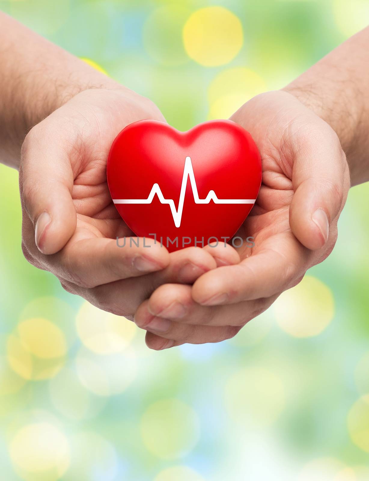 family health, charity and medicine concept - close up of hands holding red heart with cardiogram over green lights background
