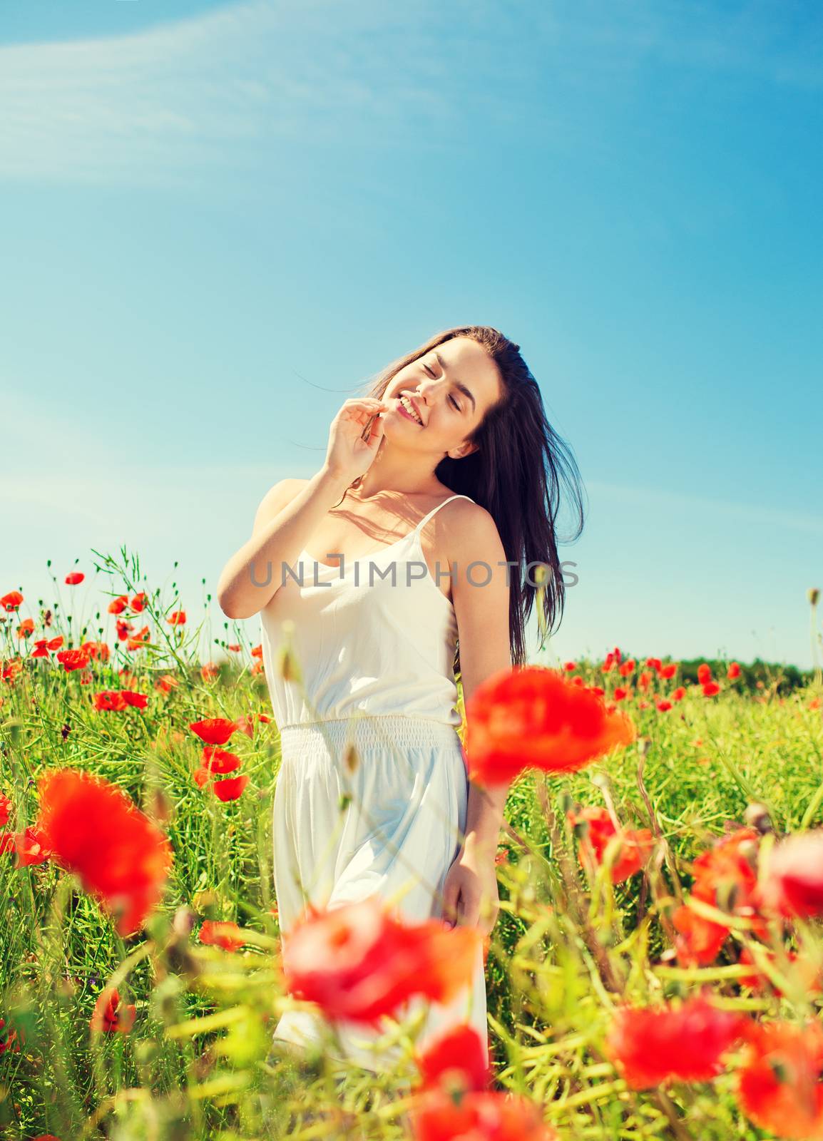 smiling young woman on poppy field by dolgachov