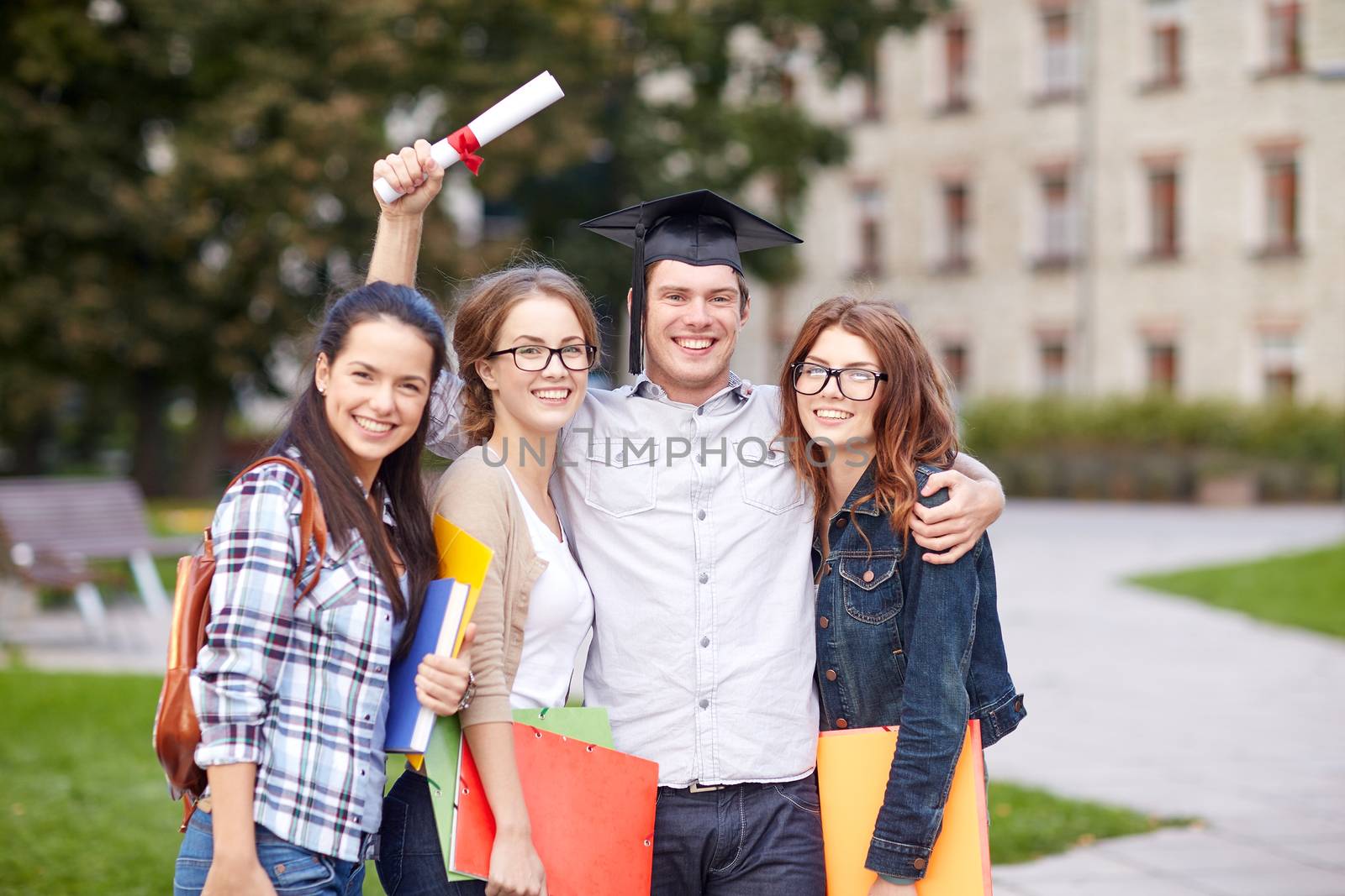 happy teenage students with diploma and folders by dolgachov