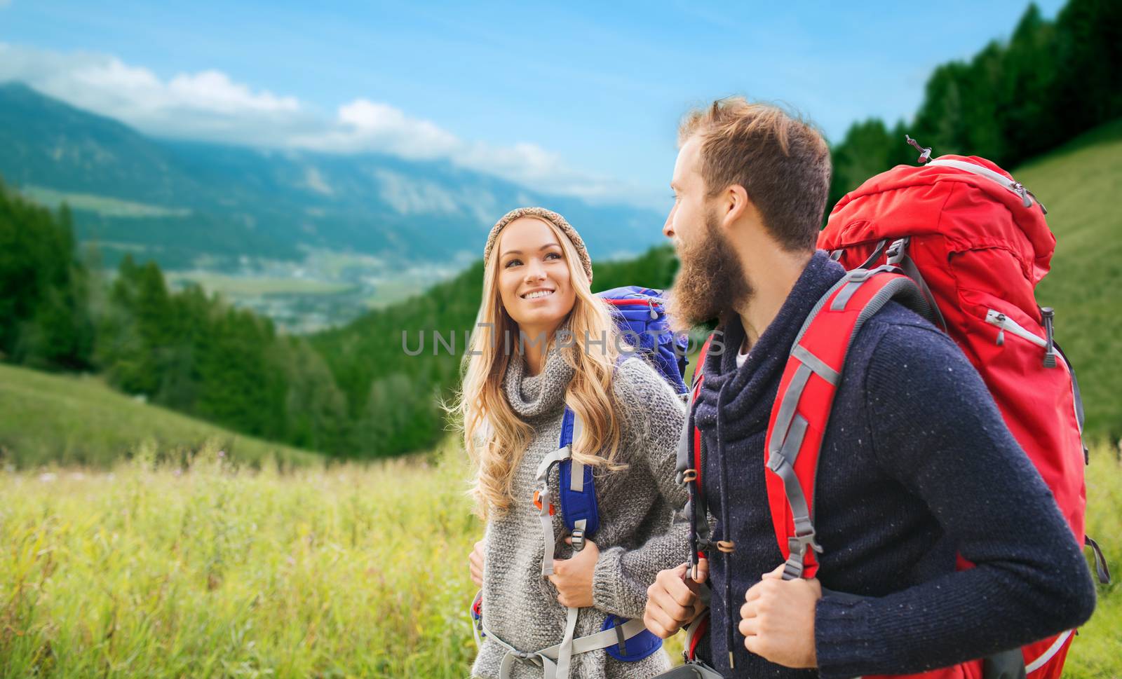 smiling couple with backpacks hiking by dolgachov