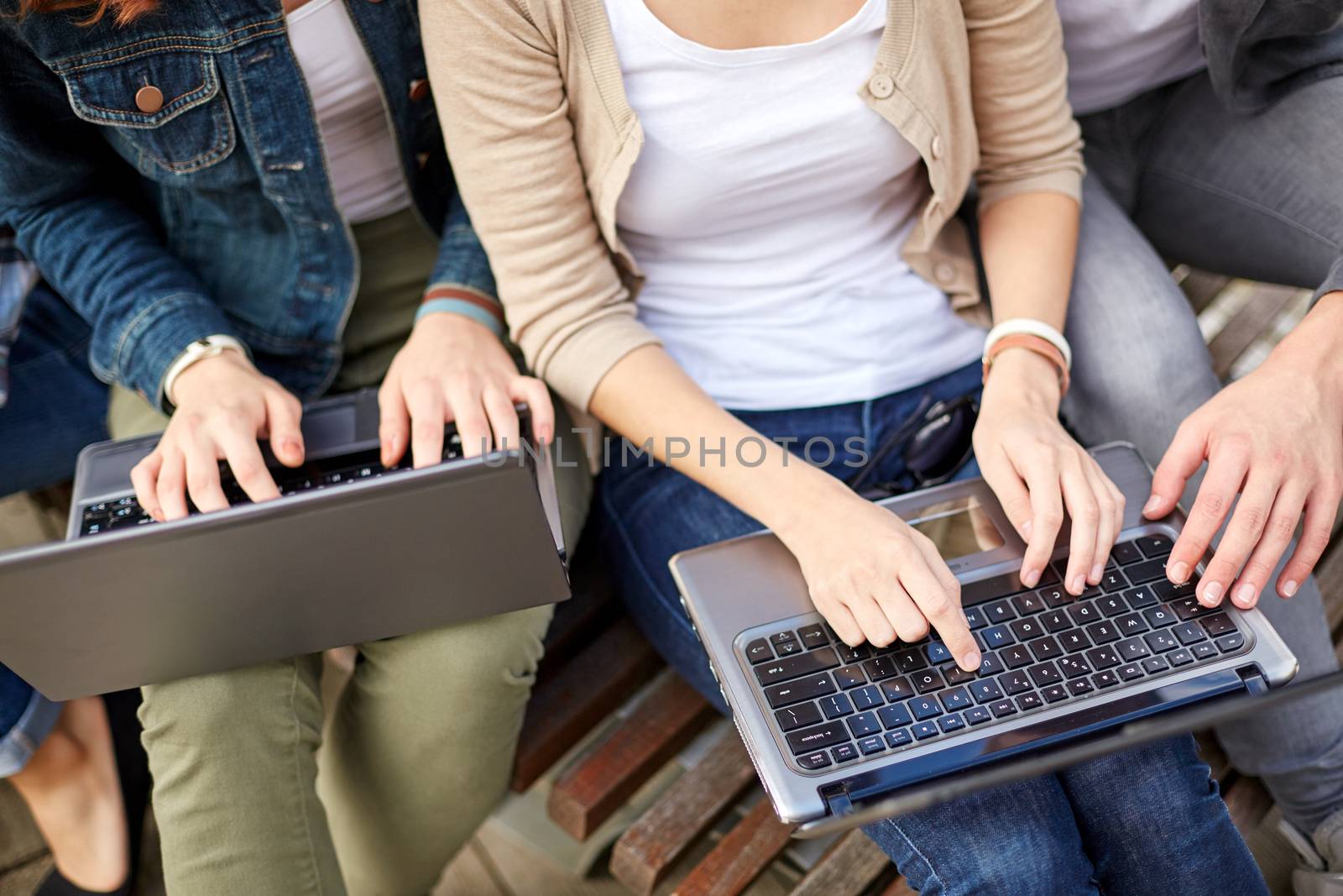 summer, internet, education, campus and people concept - close up of students or teenagers with laptop computers at campus outdoors