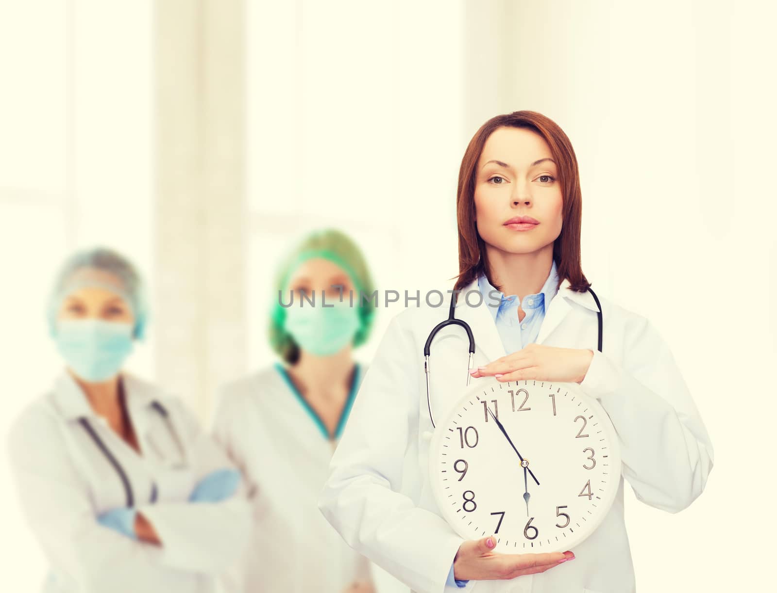 healthcare and medicine concept - calm female doctor with wall clock and stethoscope