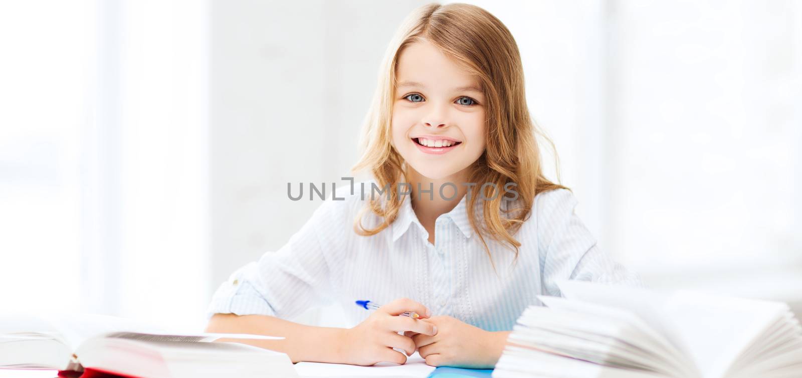 education and school concept - little student girl studying at school