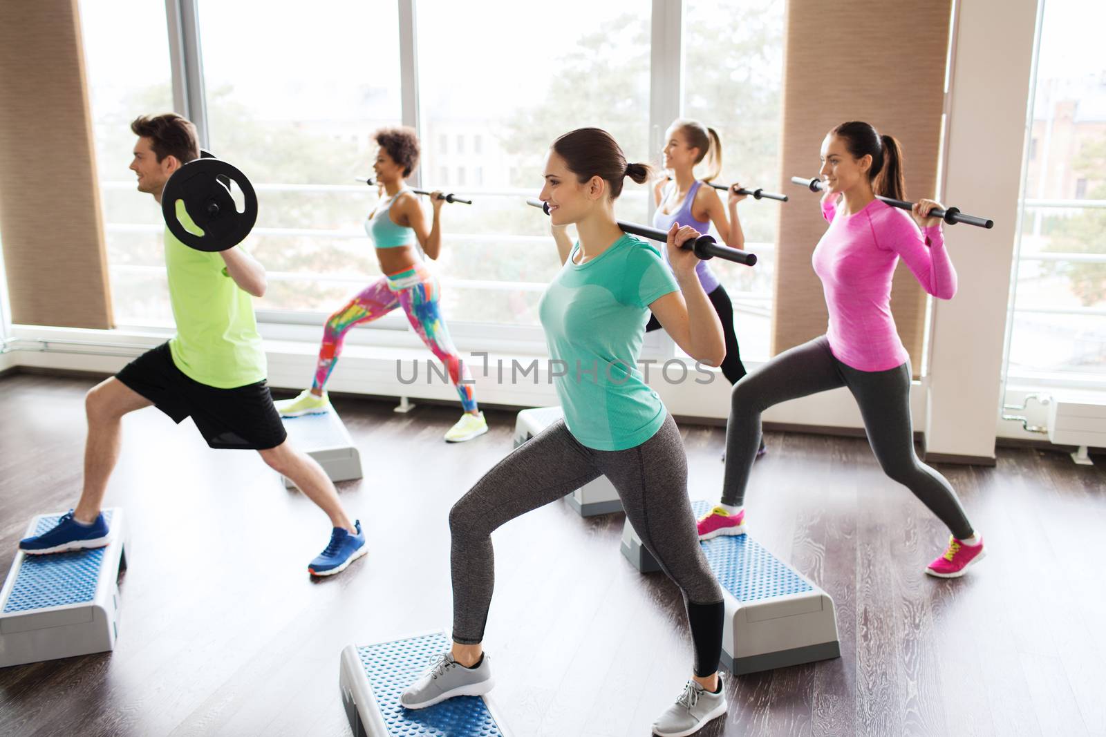 fitness, sport, training, gym and lifestyle concept - group of people exercising with barbell and bars in gym