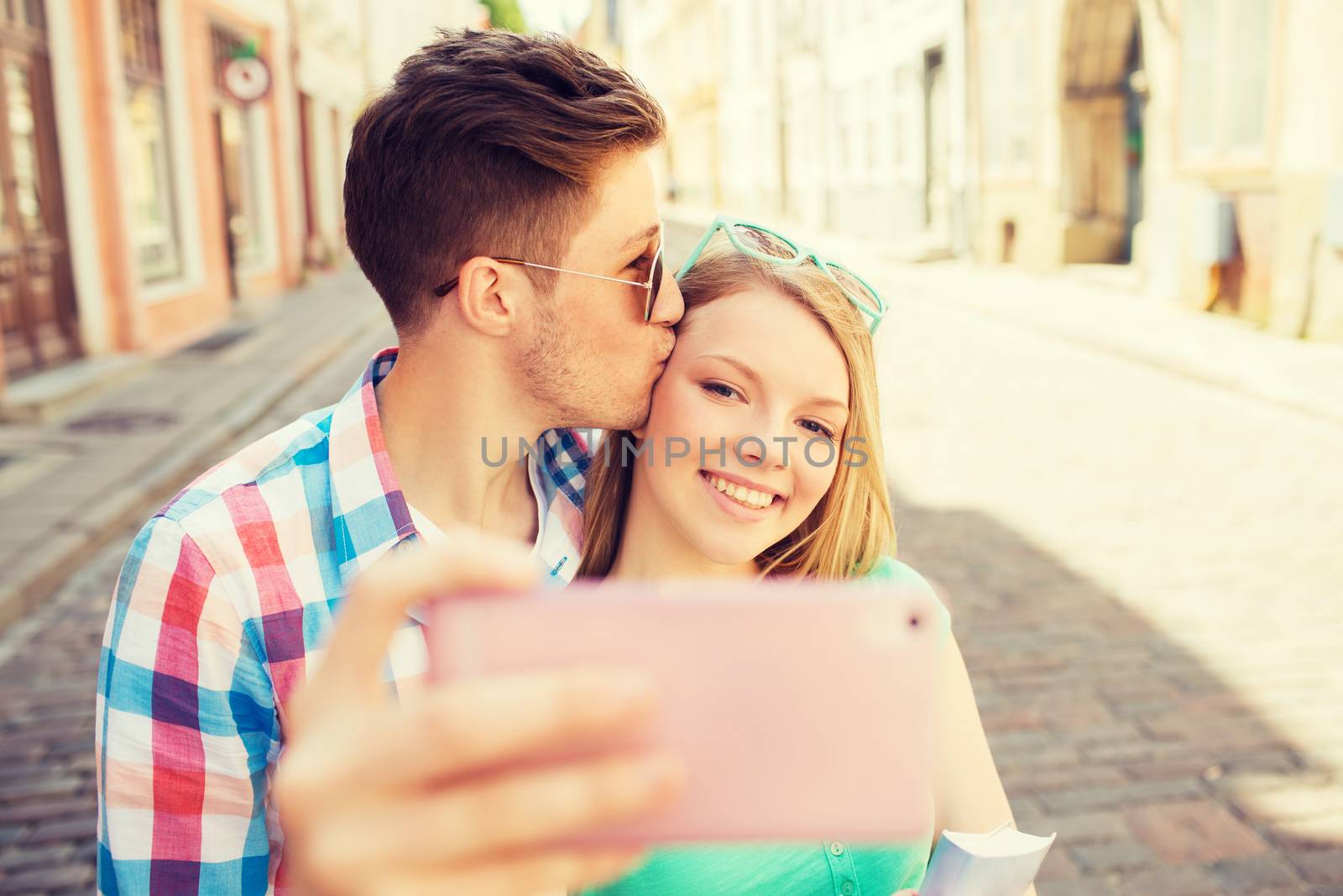 smiling couple with smartphone in city by dolgachov