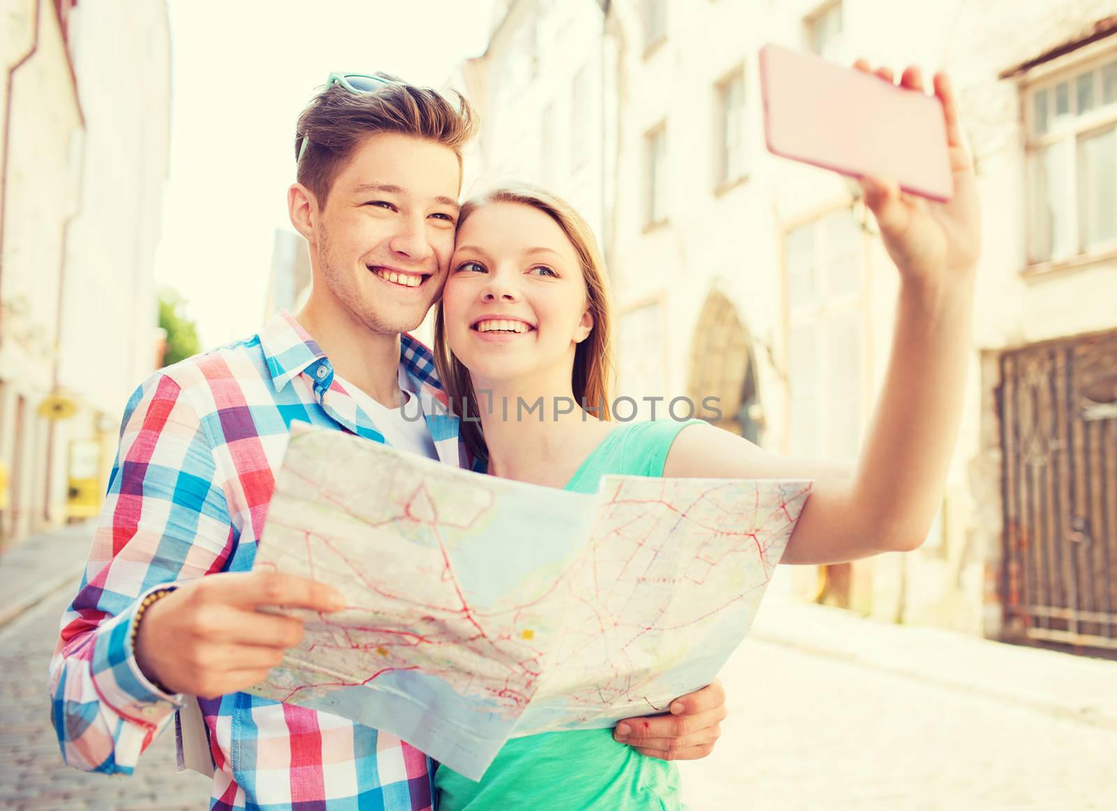 smiling couple with smartphone in city by dolgachov