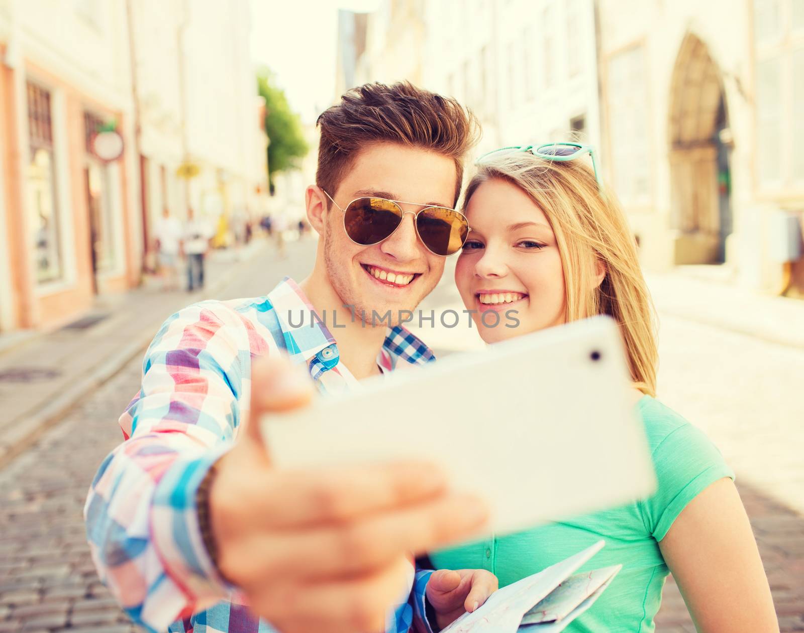 travel, vacation, technology and friendship concept - smiling couple with smartphone in city