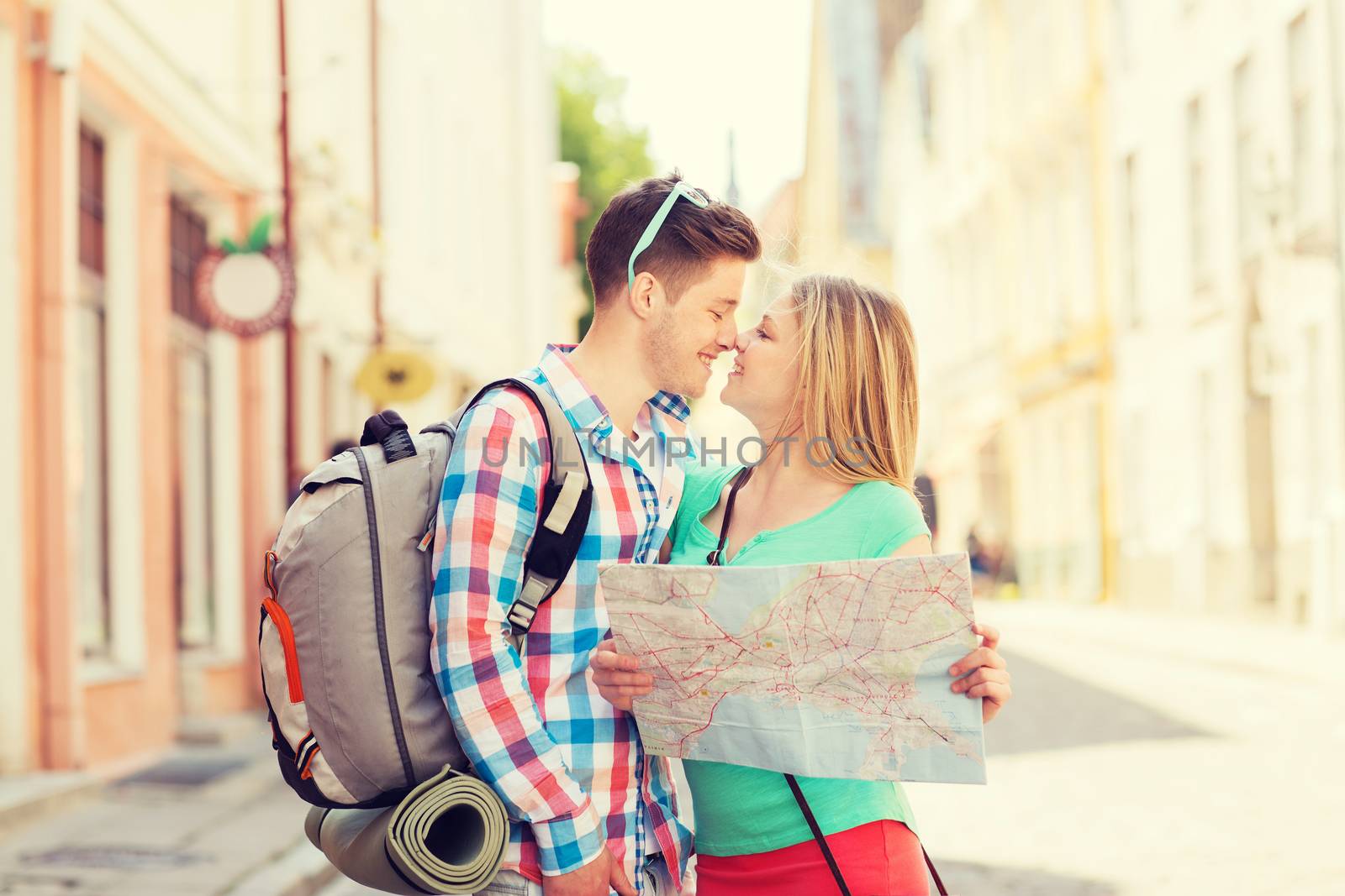 smiling couple with map and backpack in city by dolgachov