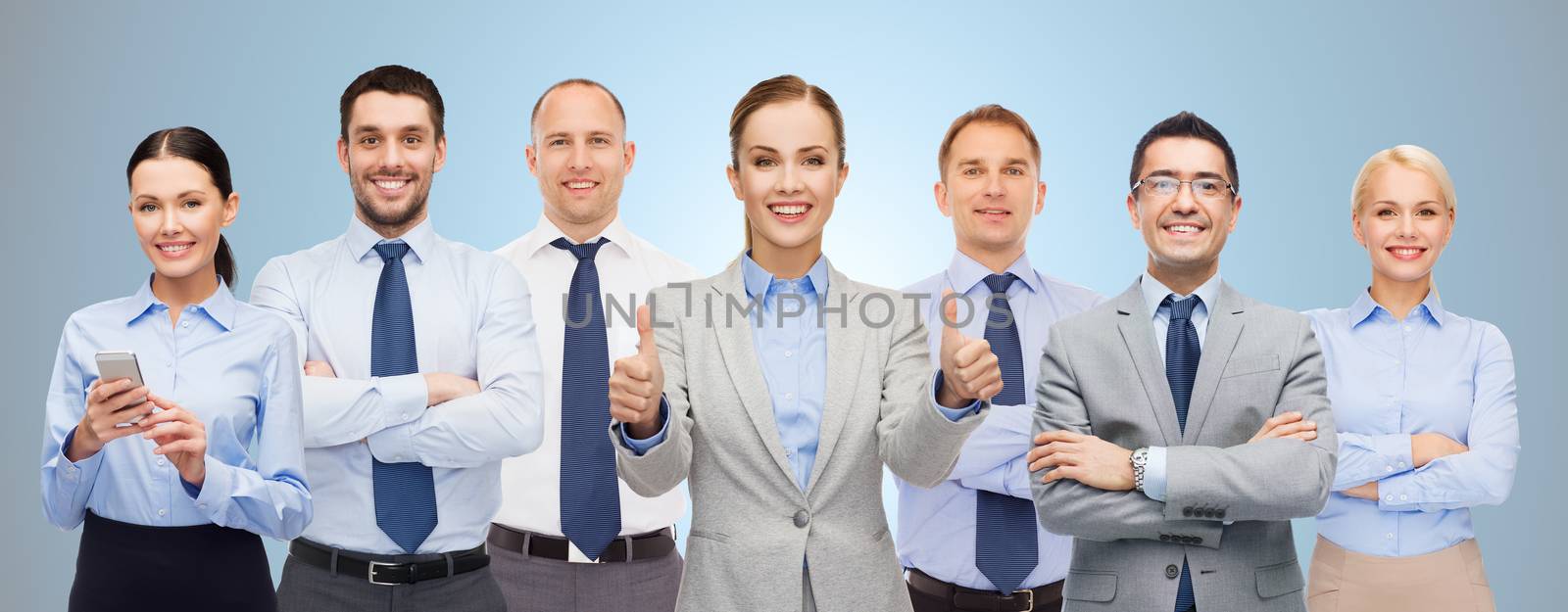 group of happy businesspeople showing thumbs up by dolgachov