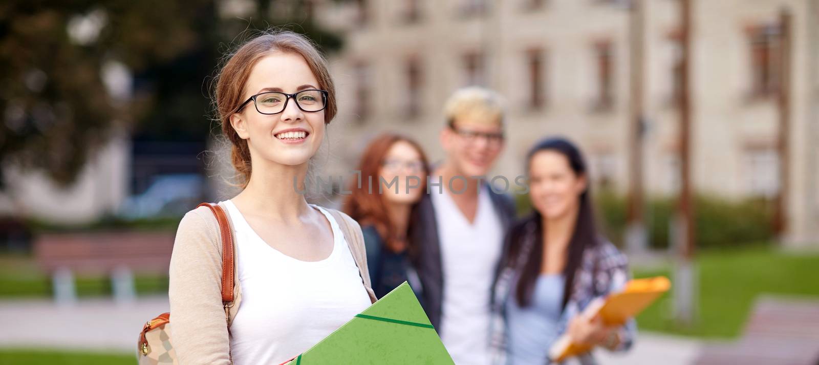 education, campus, friendship and people concept - group of happy teenage students with school folders