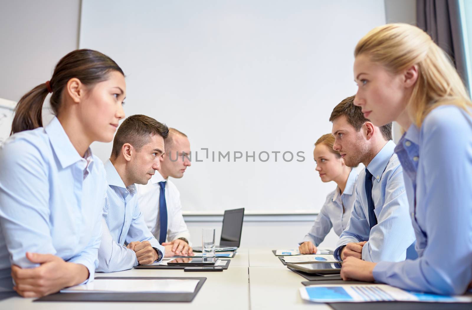 smiling business people having conflict in office by dolgachov