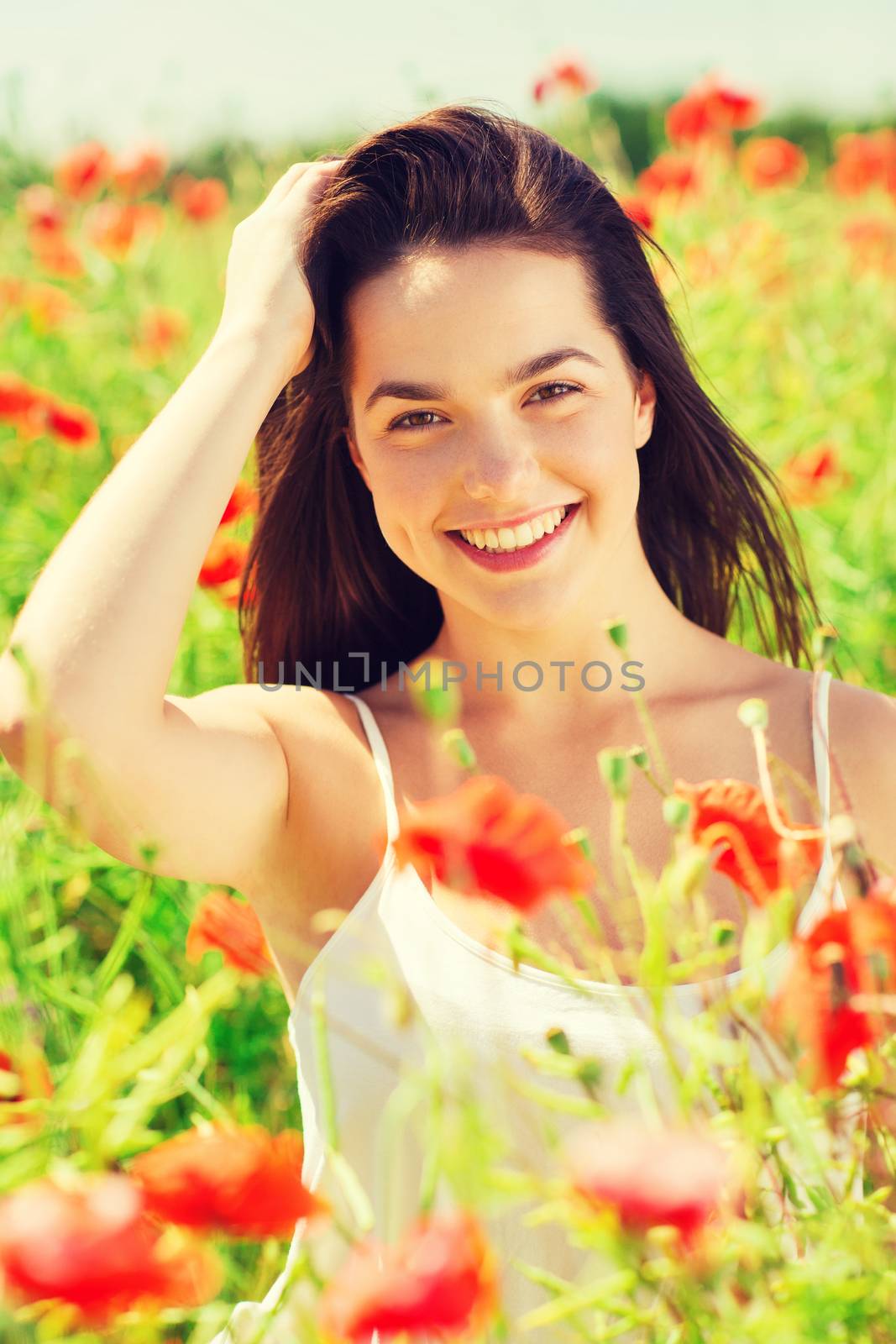 smiling young woman on poppy field by dolgachov