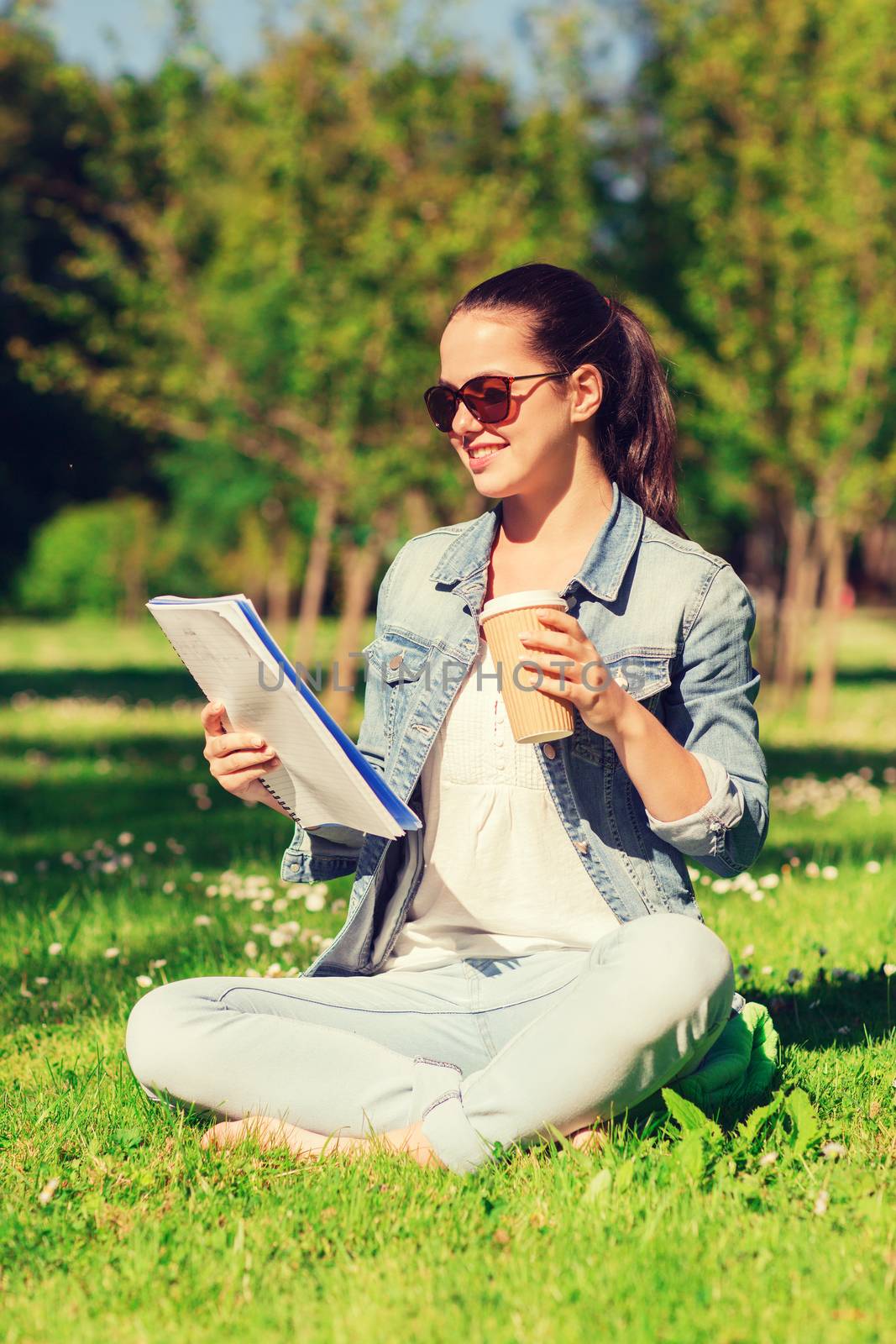 smiling young girl with notebook and coffee cup by dolgachov