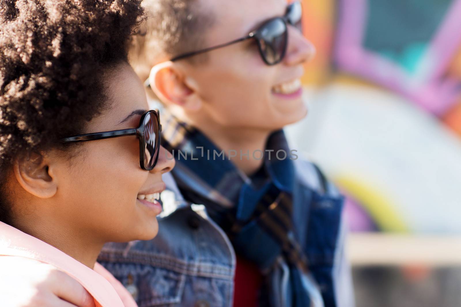 friendship, relations, tourism, travel and people concept - group of happy teenage friends or couple in sunglasses outdoors