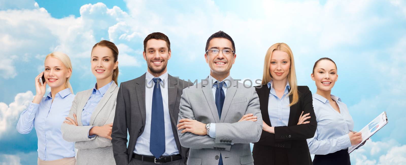group of smiling businessmen over blue sky by dolgachov