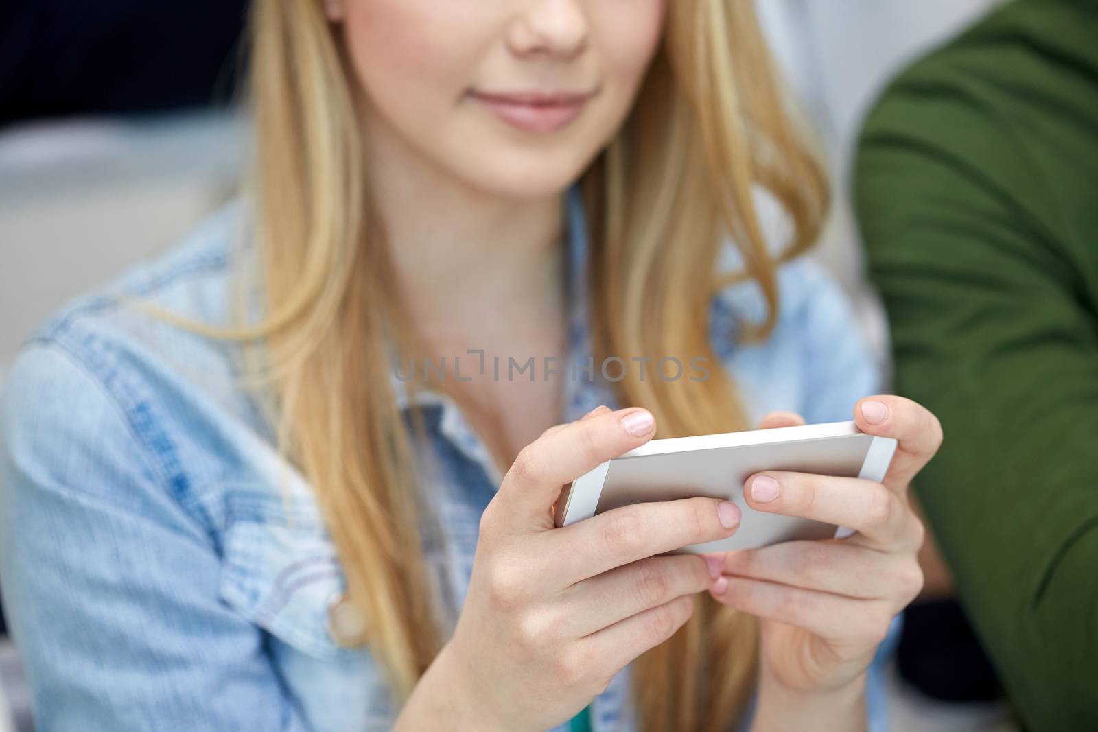 people, technology and internet concept - close up of teenage girl hands with smartphone