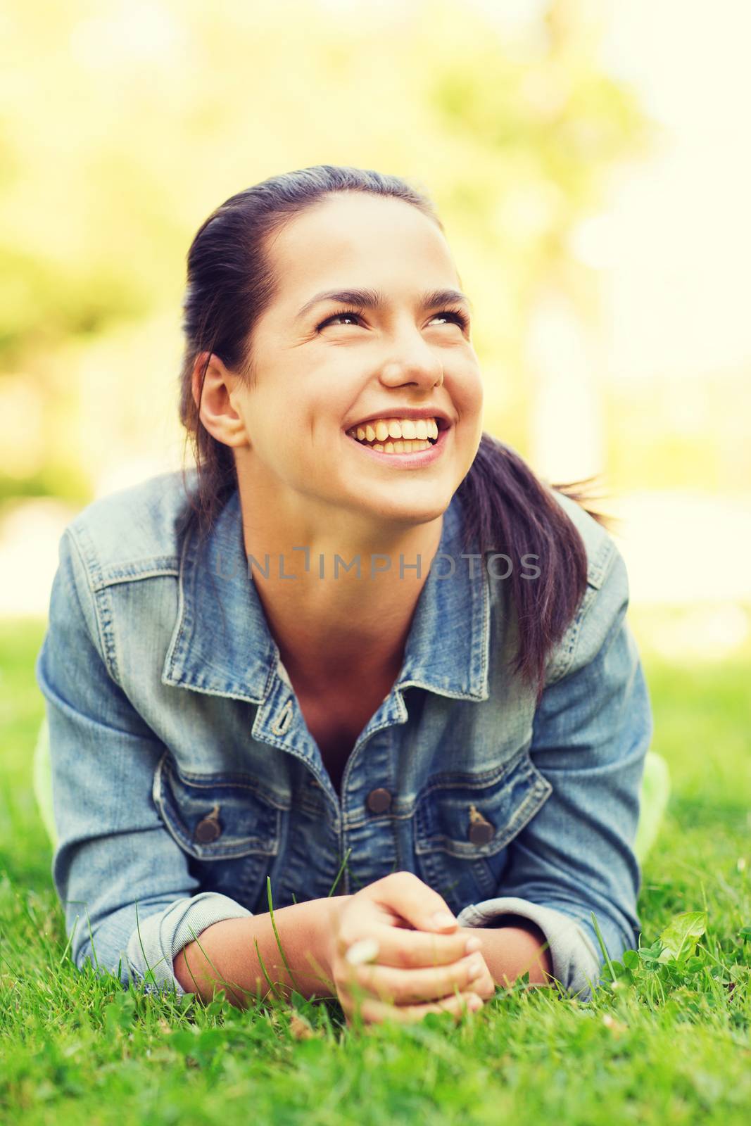 smiling young girl lying on grass by dolgachov