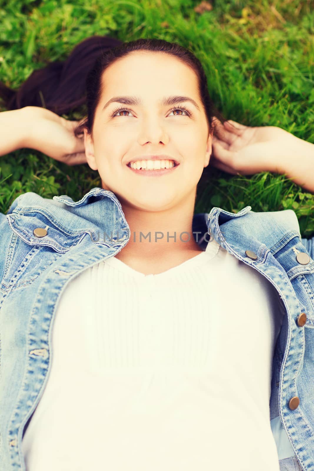 lifestyle, summer vacation, leisure and people concept - smiling young girl in blank white shirt lying on grass