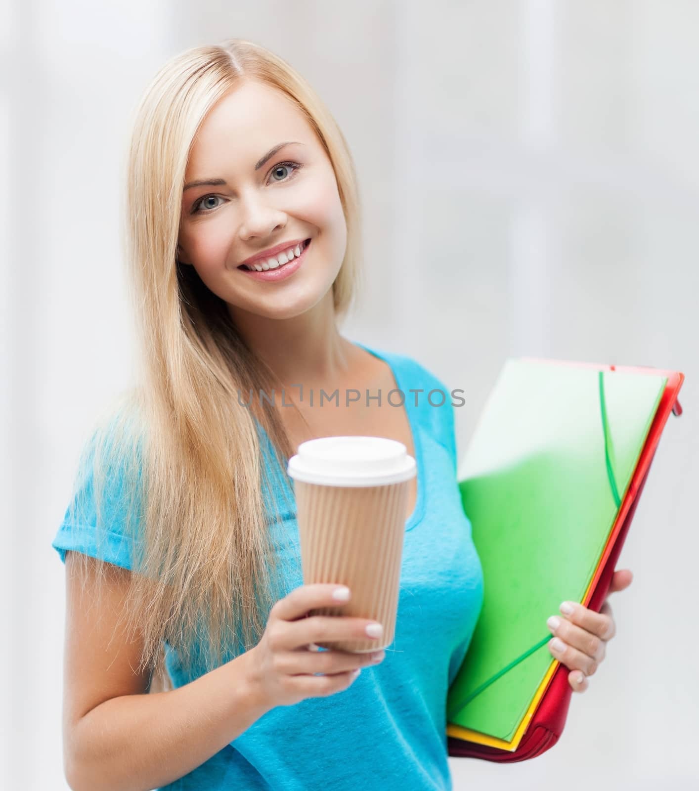 bright picture of smiling student with folders and cup of coffee