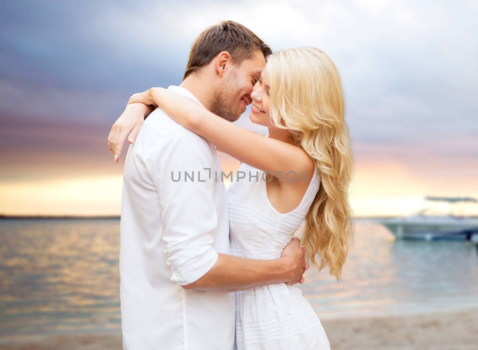summer holidays, people, love and dating concept - happy couple hugging over sunset at summer beach background