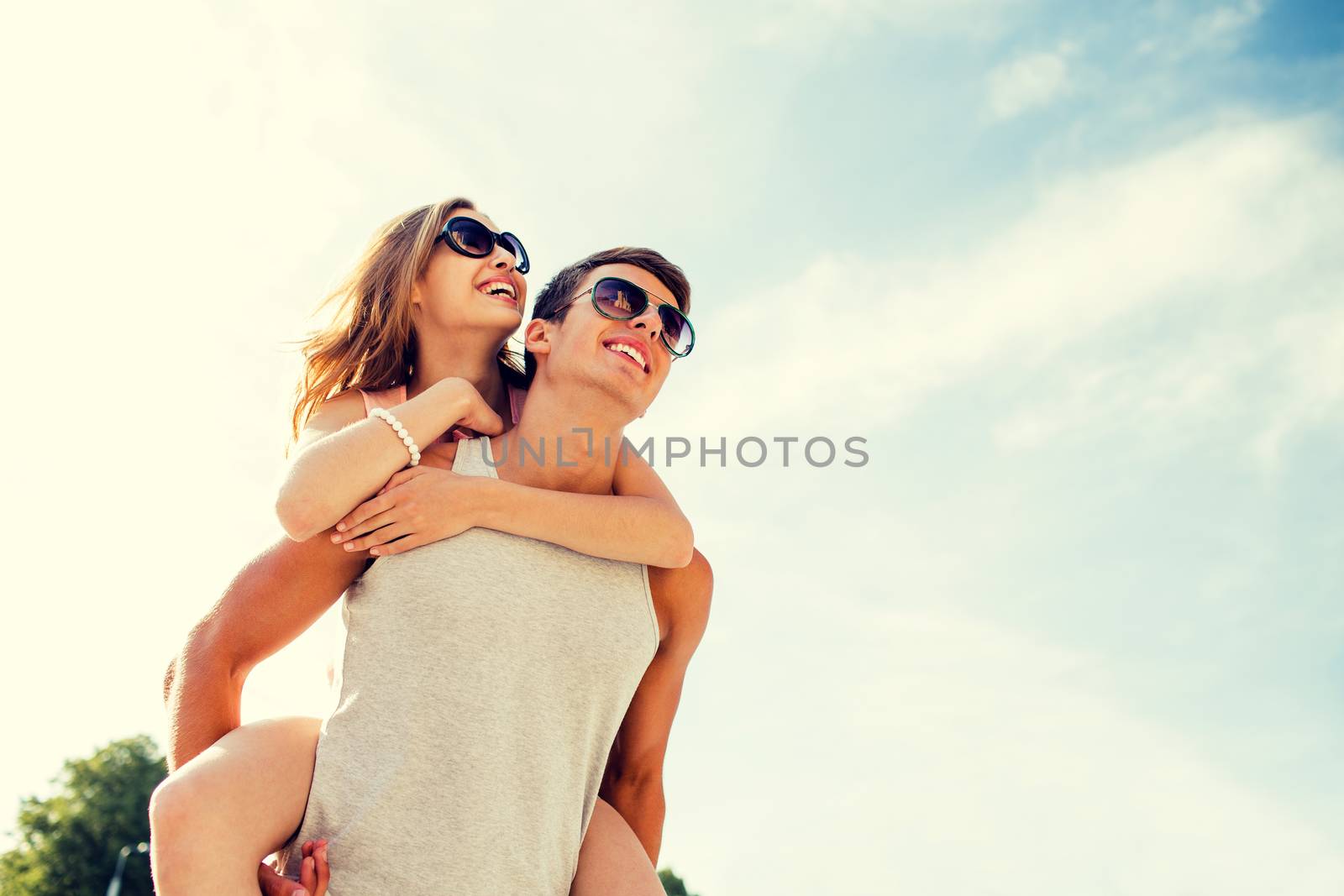 smiling couple having fun over sky background by dolgachov