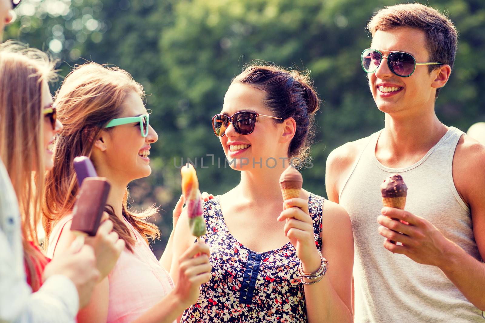 group of smiling friends with ice cream outdoors by dolgachov