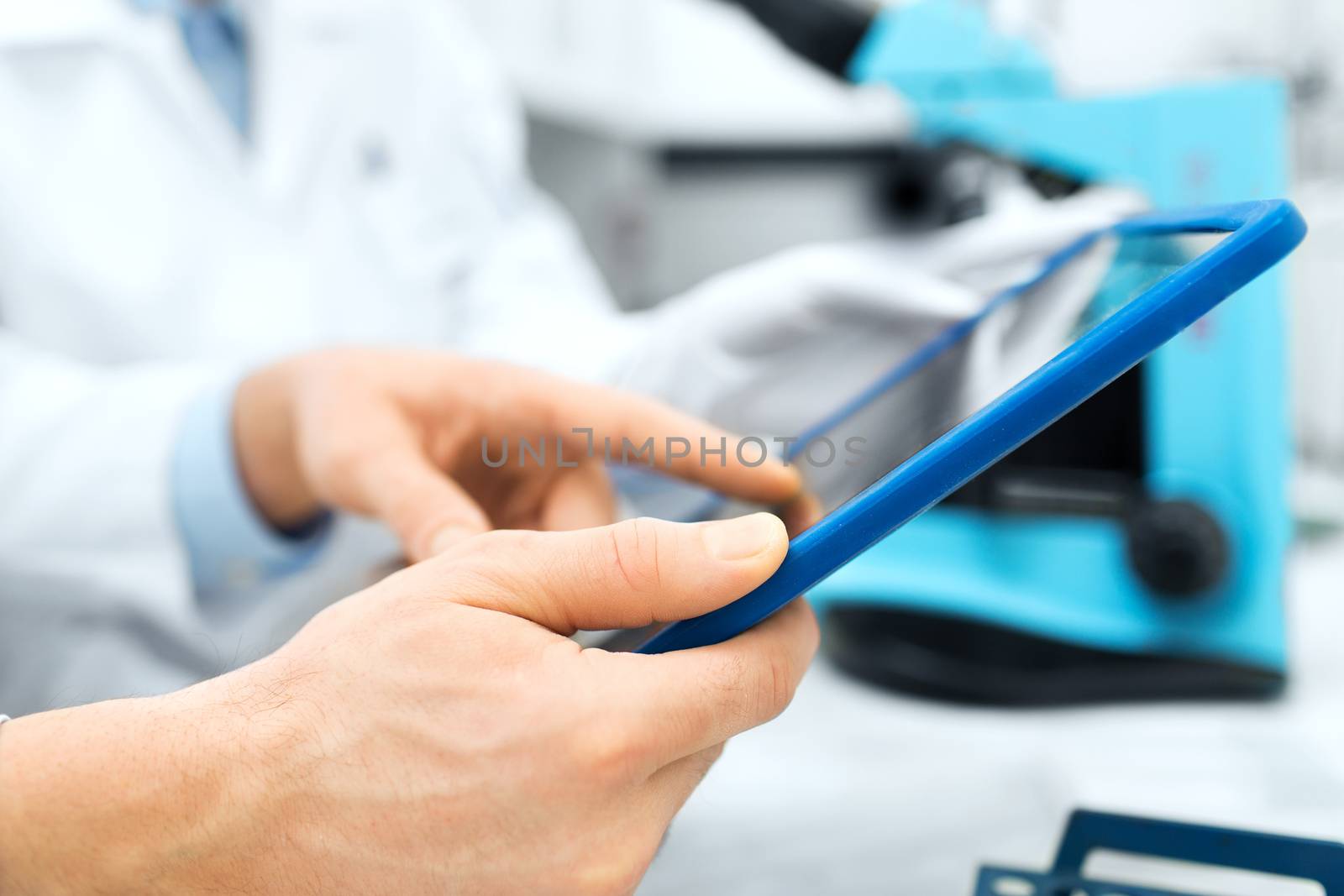 close up of scientists hands with tablet pc in lab by dolgachov