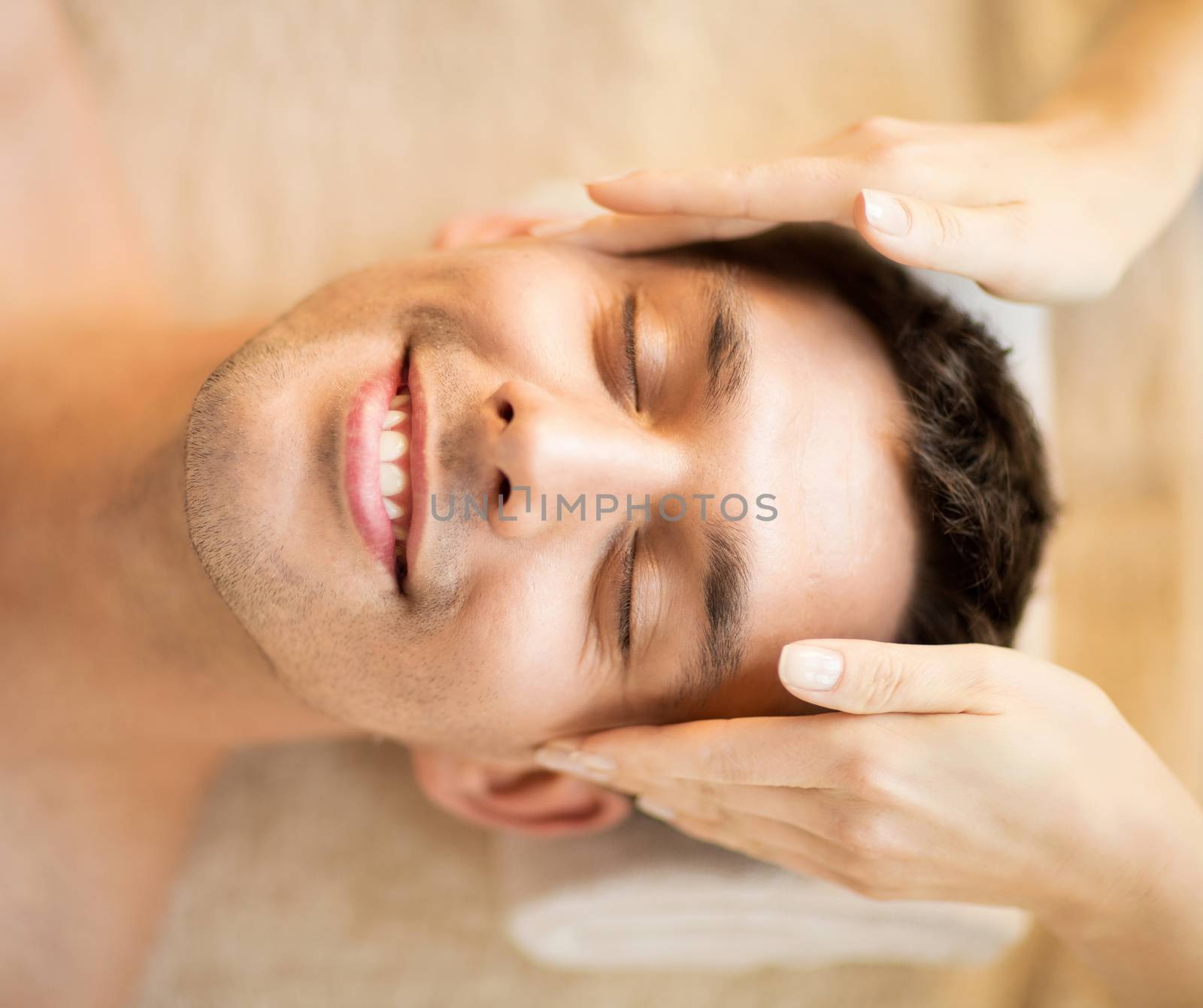 healthcare, spa and beauty concept - man is getting massage at in spa salon