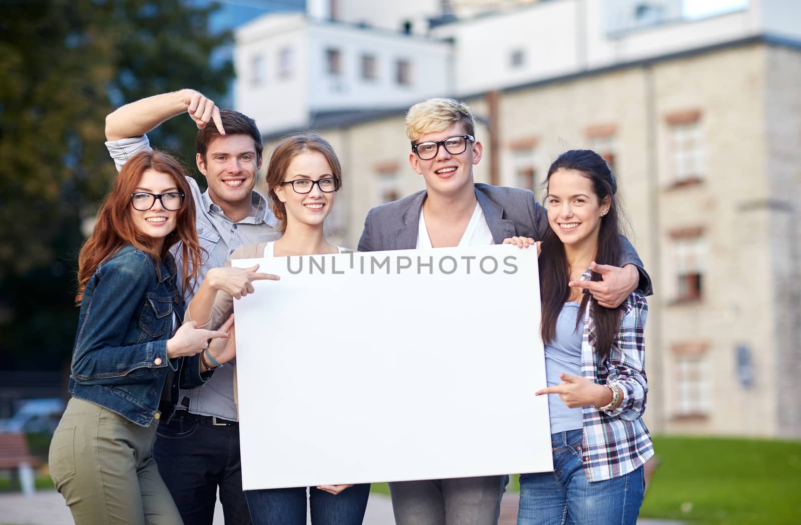 happy teenage students holding white blank board by dolgachov