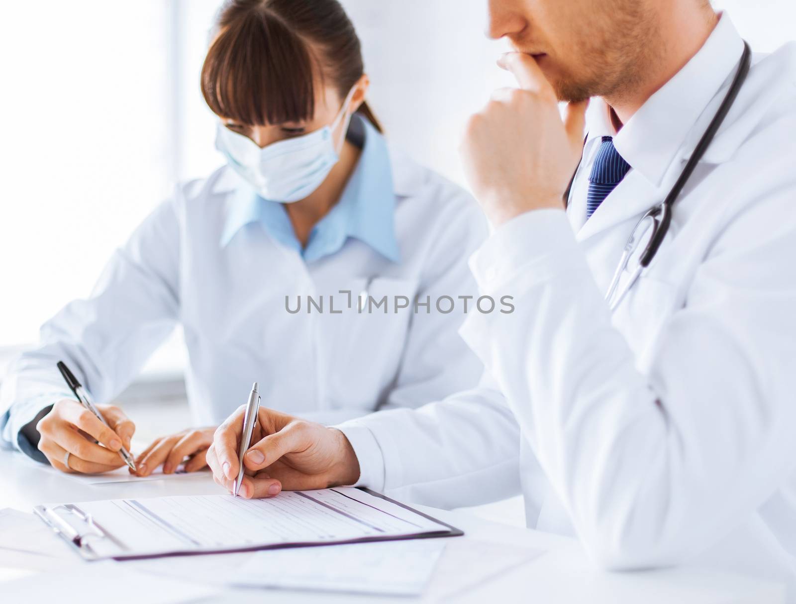 doctor and nurse writing prescription paper by dolgachov