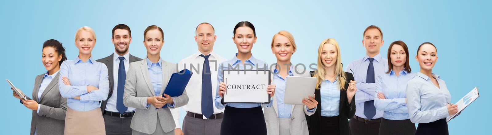 business, people, partnership, work and office concept - group of happy businesspeople holding contract over blue background