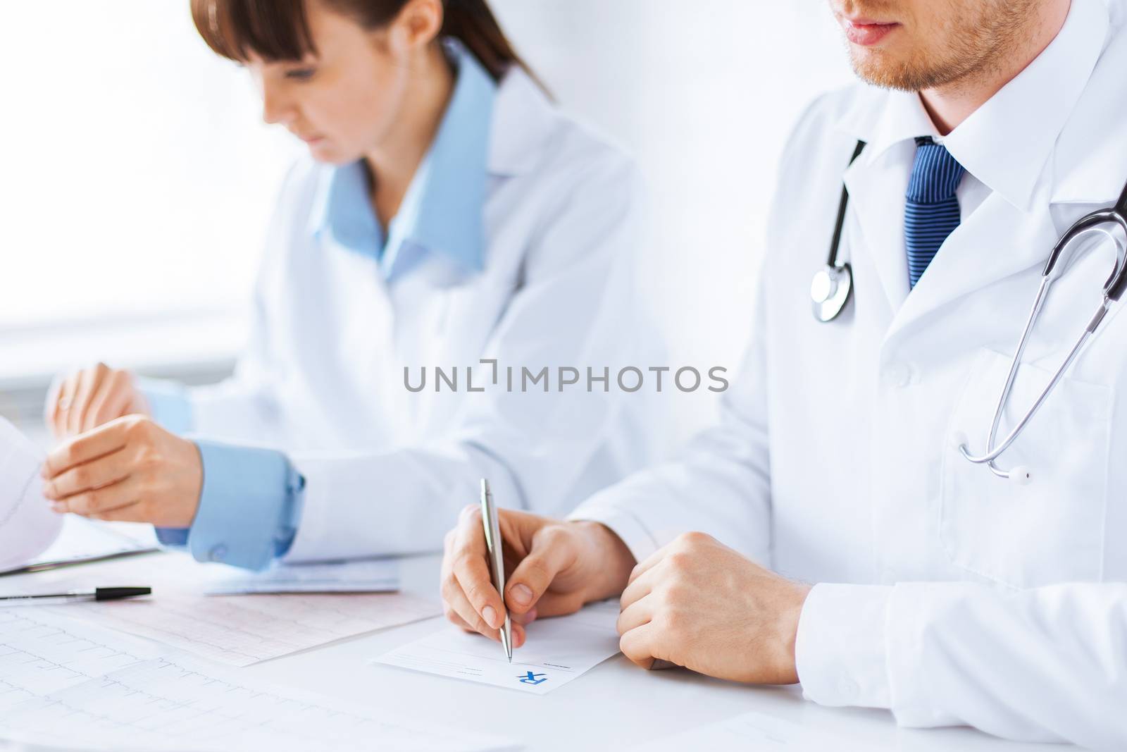 doctor and nurse writing prescription paper by dolgachov
