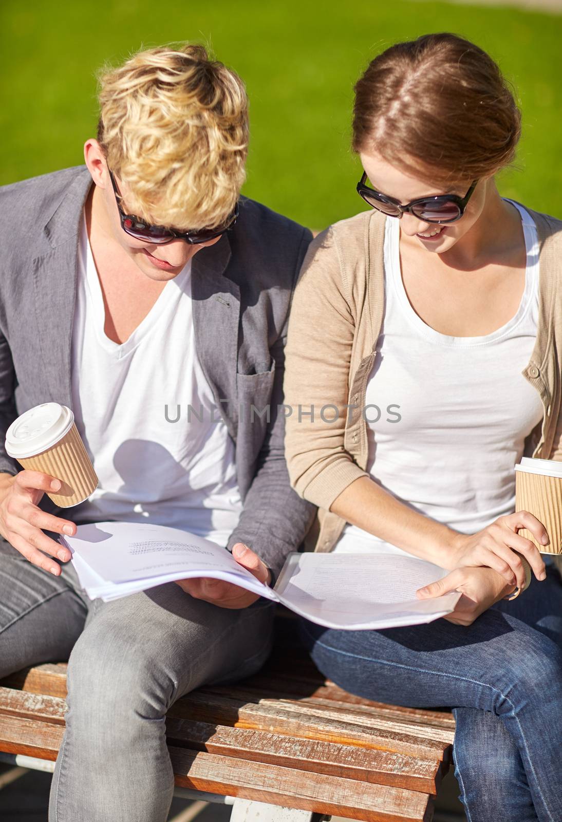 summer, friendship, education and teenage concept - f happy student couple with notebook learning and drinking coffee at campus