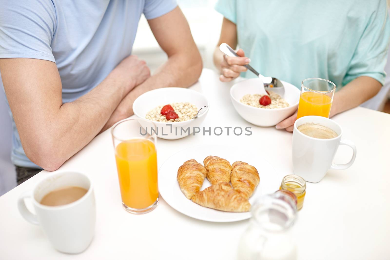 food, eating, people and healthy food concept - close up of couple having breakfast at home