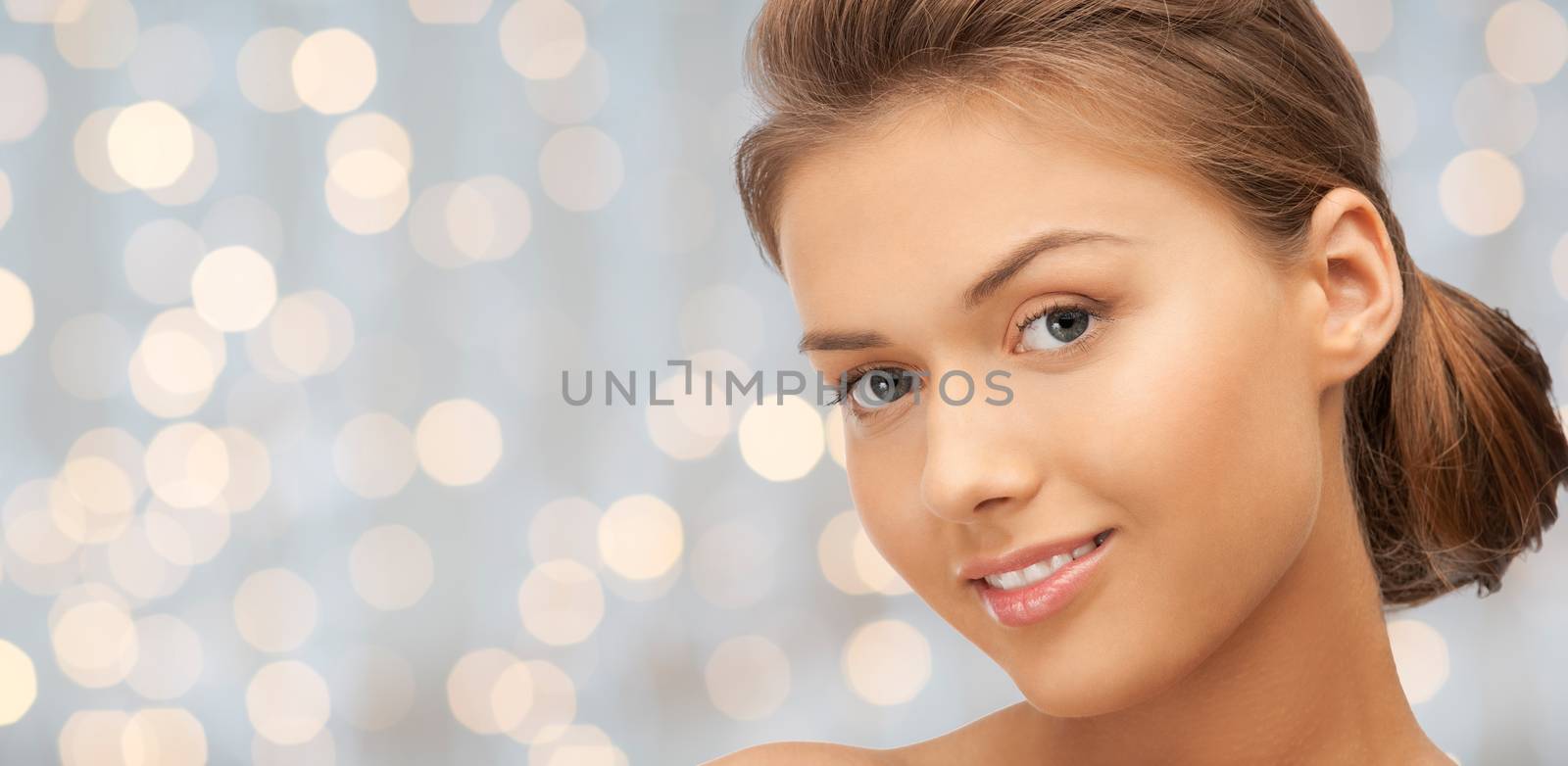 beauty, people, holidays, luxury and health concept - beautiful young woman face over lights background