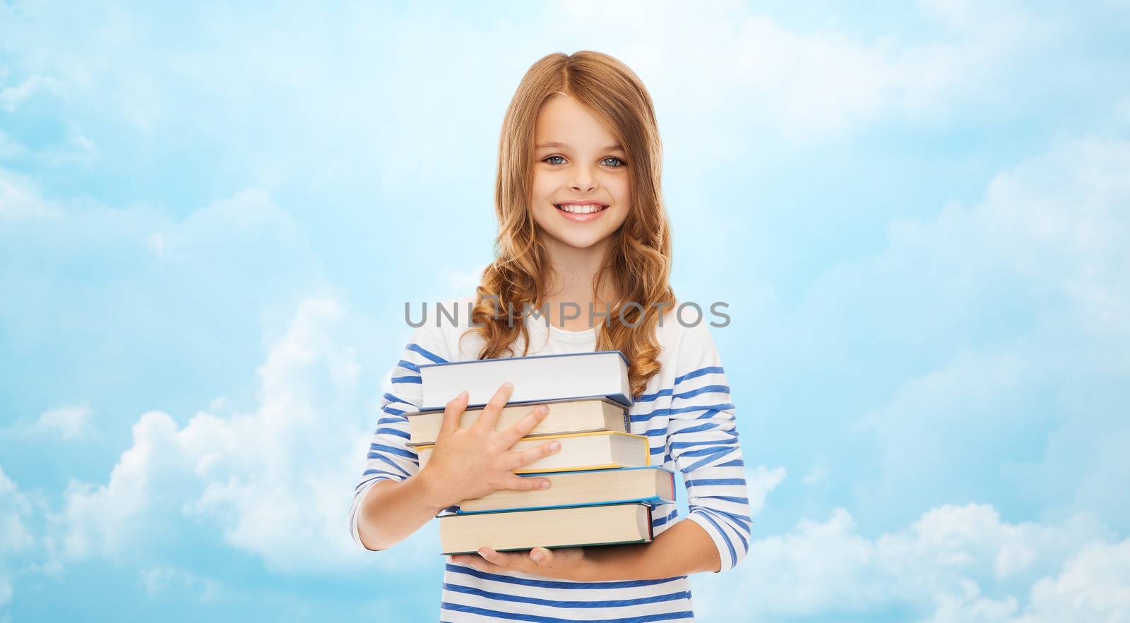 education, people, children and school concept - happy little student girl with many books over blue sky with clouds background