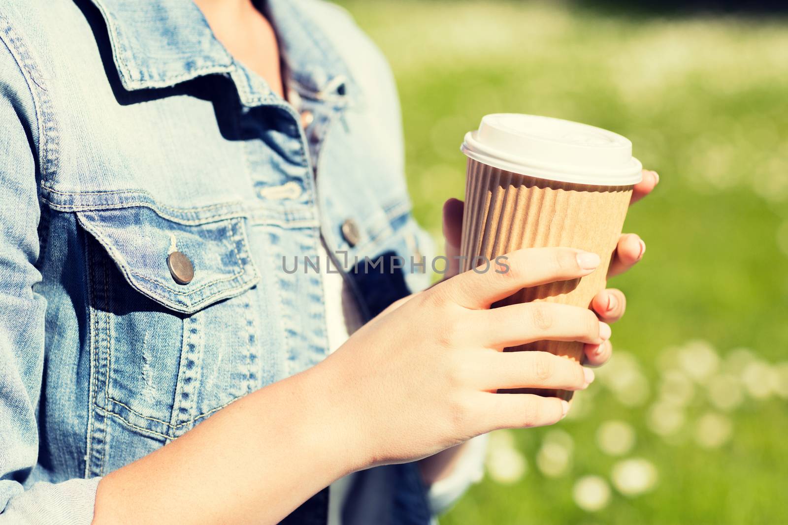 lifestyle, summer vacation, leisure, drinks and people concept - close up of young girl with coffee cup in park