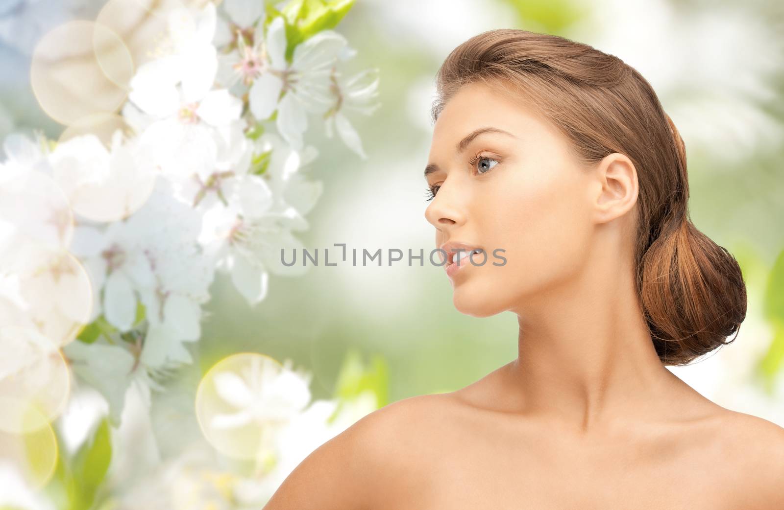 beauty, people and health concept - beautiful young woman face looking aside over green blooming garden background