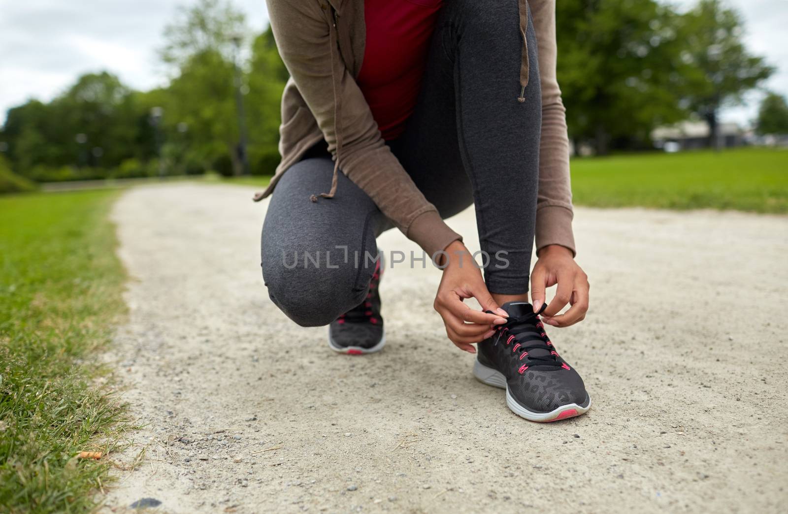 close up of woman tying shoelaces outdoors by dolgachov