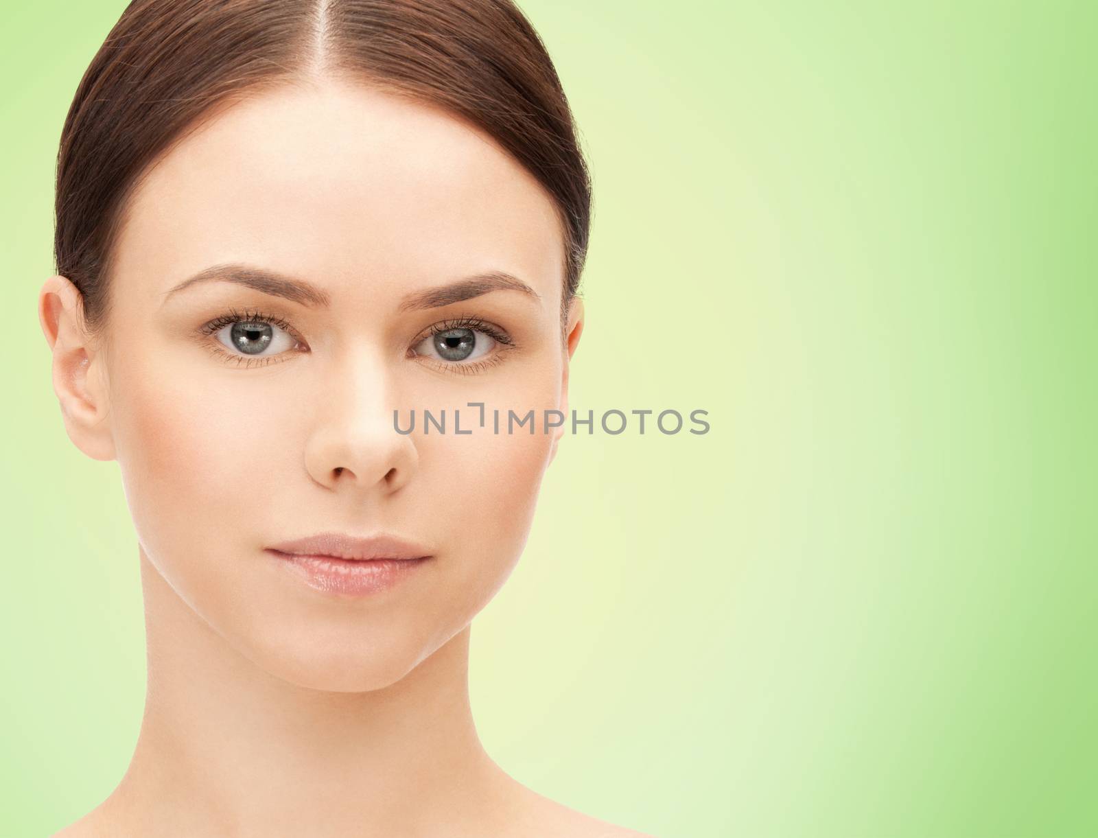 health, people, eco and beauty concept - beautiful young woman face over green background